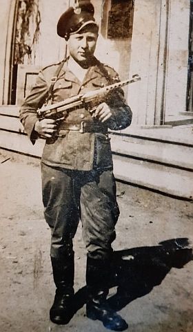 Czesław Sandomierski w mundurze z bronią w ręku
